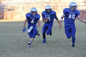 Jackson Waddell carries the ball in front of blockers Blake Curtin (4) and JJ Harris (40). Photo Courtesy of Asa Nelson